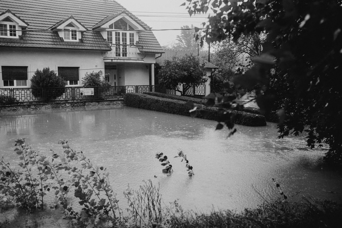 Illustrative black-and-white stock photo of floodwater surrounding a house
